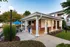 Charming outdoor patio with covered seating area, vibrant blue umbrellas, and lush greenery, perfect for relaxing or entertaining.