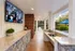 Elegant outdoor entertainment area featuring a luxury granite countertop with a built-in sink, under a charming covered patio with brick accents and serene garden views.