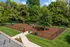Inviting fenced dog park with agility equipment, surrounded by lush greenery and a picnic area for relaxation.