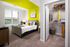 Bright and stylish bedroom featuring a cozy bed, modern decor, vibrant accent wall, and spacious walk-in closet.