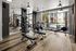 Bright, modern fitness center with sleek gym equipment, large mirrors, and expansive windows offering a poolside view.