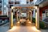 Charming outdoor patio with stylish wooden pergola, cozy seating, and ambient lighting at a modern apartment complex.