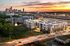Vibrant cityscape view featuring modern apartments with stunning sunset backdrop, ideal urban living in a lively neighborhood.