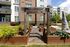 Charming garden view from a modern apartment complex, highlighting raised wooden planters and colorful outdoor art in a vibrant community setting.