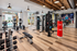 Modern fitness center with premium equipment, featuring cardio machines, weight lifting area, and boxing setup, overlooking a scenic outdoor pool.