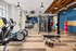 Modern fitness center with state-of-the-art equipment, treadmills, weights, and a punching bag under stylish lighting and wood accents.