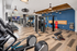 Modern fitness center featuring state-of-the-art equipment, including treadmills, weight machines, and exercise bikes, set against elegant wood flooring and stylish lighting.