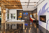 Chic entertainment room with polished floors, featuring a pool table, arcade games, and a cozy fireplace, ideal for leisure and social gatherings.