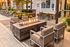 Chic outdoor seating area featuring a cozy fire pit, surrounded by modern chairs and vibrant greenery.