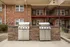 Charming apartment patio with two stainless steel BBQ grills and rustic stone surround, perfect for outdoor entertaining.