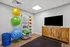 Modern home gym with bright exercise balls, vibrant resistance bands, and a sleek TV for workout entertainment.