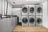 Contemporary laundry room with modern washer and dryer units, featuring sleek gray finish and convenient stackable design.