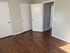 Inviting room with elegant hardwood flooring and clean, white doors offering a blank canvas for personalization.