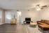 Inviting living room with modern decor, featuring a cozy brown sofa, stylish wooden coffee table, and sleek TV unit under warm ambient lighting.