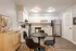 Contemporary kitchen and dining space with sleek black chairs and stainless steel appliances, exuding modern elegance.