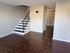 Chic apartment interior featuring sleek wooden floors and a stylish staircase leading to the upper level.