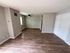 Modern living area with sleek hardwood floors, neutral walls, and ample natural light, perfect for stylish interiors.
