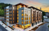 Modern apartment complex at sunset, featuring sleek architectural design with large windows and warm lighting.