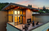 Stunning rooftop apartment with modern architecture, cozy fireplace, and outdoor seating, capturing a beautiful sunset view.