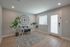 Bright and modern home office with elegant decor, featuring a sleek glass desk, comfortable chair, and large wall clock, perfect for productivity and style.