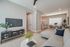Modern open-concept living room with a cozy L-shaped sofa, chic dining area, and stylish breakfast bar under elegant pendant lights.