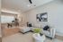 Modern open-concept living and dining area with elegant decor, featuring a cozy sectional sofa and stylish dining set, complemented by chic artwork and natural light.