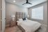 Elegant bedroom featuring a plush queen-sized bed, soothing neutral decor, and abundant natural light through a large window with blinds.