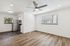 Bright and modern open floor plan with sleek hardwood floors, a stylish ceiling fan, and a contemporary kitchen featuring stainless steel appliances.