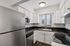 Modern kitchen featuring stainless steel appliances, elegant cabinetry, and a large window for natural light.