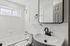Bright, modern bathroom featuring sleek black fixtures, a pristine white tub, and a large mirror, perfect for a refreshing start to your day.