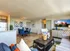 Bright and modern open-plan living area with stylish decor, featuring a comfortable lounge, elegant dining set, and contemporary artwork.