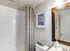 Modern bathroom featuring elegant geometric shower curtain, contemporary wall art, and sleek fixtures.