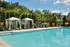 Luxurious outdoor pool area with chic cabanas and lush greenery under a bright sky, perfect for relaxation and leisure.
