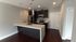 Modern kitchen featuring sleek cabinetry, an elegant island with a built-in sink, and stainless steel appliances.