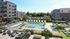 Inviting luxury apartment complex with a stunning outdoor pool area surrounded by lounge chairs and lush greenery.