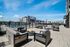 Inviting outdoor lounge with modern seating and fire pits overlooking a pool in a contemporary apartment complex.
