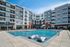 Chic apartment complex with a sparkling pool, modern architecture, and inviting outdoor lounge area.