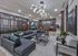 Luxurious living room with a contemporary grey sectional sofa, designer lighting, and an open kitchen space.
