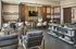 Modern lounge area with stylish seating, wall decor, and a sleek bookshelf in a sophisticated ambiance.
