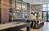 Modern entertainment lounge featuring a sleek kitchen bar, artistic decor, and a pool table.