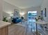 Bright living room featuring a stylish blue sofa, modern decor, and a view through sliding glass doors.
