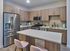 Contemporary kitchen with stainless steel appliances, wooden cabinetry, and central island with seating.
