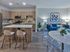 Stylish open-plan kitchen and living area with modern decor, featuring a sleek island, contemporary furniture, and vibrant artwork.