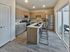 Sleek modern kitchen featuring wooden cabinetry, stainless steel appliances, and an island with bar seating.