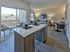 Beautiful open-concept kitchen and living room with modern furnishings and a balcony view.