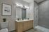 Modern bathroom featuring a dual-sink vanity, sleek shower with glass door, and stylish decor.