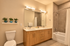 Sleek modern bathroom with double vanity, large mirror, and decorative vases, featuring a tub with shower.