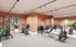 Modern fitness center with state-of-the-art gym equipment, exposed brick walls, and vibrant decor.