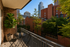 Inviting urban balcony with cozy seating and lush greenery, offering stunning cityscape views.