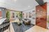 Inviting living space with modern furnishings, featuring a cozy curved sofa, stylish accent chairs, and vibrant wall decor, perfect for relaxation.